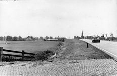 847454 Gezicht op de Ingenieur Enschedeweg (N212 Woerden - Mijdrecht), met op de achtergrond de toren van de kerk van ...